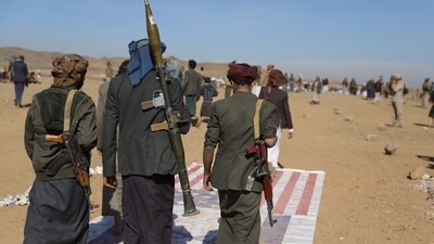 Tribesmen loyal to the Houthis walk on U.S. and Israeli flags at the site of a parade for new tribal recruits amid escalating tensions with the US-led coalition in the Red Sea. (Reuters)