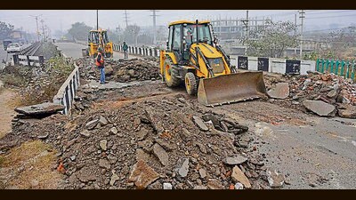 PWD employees dismantling the old bridge over Buddha Nullah near Chand Cinema to reconstruct a new bridge in Ludhiana. (HT)