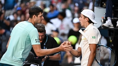 Poland's Hubert Hurkacz (L) shakes hands with France's Arthur Cazaux after the end of their men's singles match on day nine of the Australian Open tennis tournament in Melbourne on January 22 (AFP)