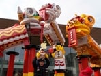 A man lifts a child on his shoulders near Chinese New Year themed decoration ahead of the upcoming Chinese Lunar New Year in Beijing, China on Saturday, Jan. 20, 2024. (AP Photo/Ng Han Guan)