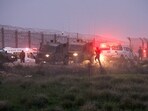 Israeli soldiers walk next to military vehicles and ambulances, as the conflict continues between Israel and the Palestinian group Hamas