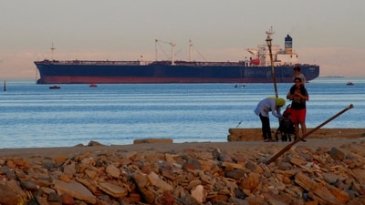 FILE PHOTO: People walk on the beach as a container ship crosses the Gulf of Suez towards the Red Sea before entering the Suez Canal, in El Ain El Sokhna in Suez, east of Cairo, Egypt April 24, 2017. REUTERS/Amr Abdallah Dalsh/File Photo (REUTERS)