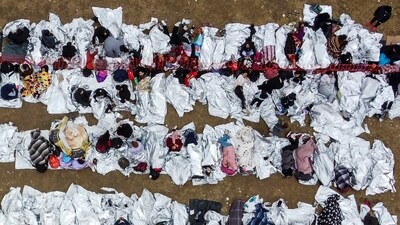 TOPSHOT - This aerial view shows immigrants waiting to be processed at a US Border Patrol transit center after they crossed the border from Mexico in Eagle Pass, Texas, on December 22, 2023. The Republican governor of Texas signed a bill on December 18, 2023 that would allow state police to arrest and deport migrants who cross illegally into the United States from Mexico. (Photo by CHANDAN KHANNA / AFP) (AFP) TOPSHOT - This aerial view shows immigrants waiting to be processed at a US Border Patrol transit center after they crossed the border from Mexico in Eagle Pass, Texas, on December 22, 2023. The Republican governor of Texas signed a bill on December 18, 2023 that would allow state police to arrest and deport migrants who cross illegally into the United States from Mexico. (Photo by CHANDAN KHANNA / AFP) (AFP)