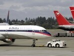 FILE - A Delta Airlines jet is pulled into position at left next to aircraft operated by Northwest Airlines. (AP Photo/Ted S. Warren, File) FILE - A Delta Airlines jet is pulled into position at left next to aircraft operated by Northwest Airlines. (AP Photo/Ted S. Warren, File)