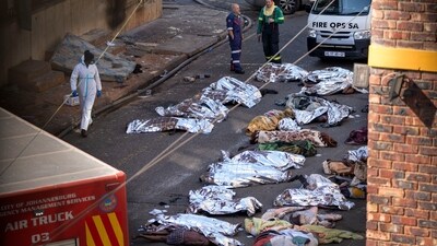 Medics stand by the covered bodies of victims of a deadly blaze in downtown Johannesburg, Thursday, Aug. 31, 2023. (AP) Medics stand by the covered bodies of victims of a deadly blaze in downtown Johannesburg, Thursday, Aug. 31, 2023. (AP)