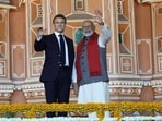 Prime Minister Narendra Modi and French President Emmanuel Macron wave during a roadshow in Jaipur.