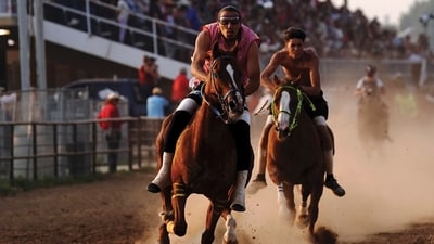 S/M Express' Desmond Archilta, right, competes during the second heat of the World Championship Indian Relay Race during the Sheridan WYO Rodeo, Friday, July 14, 2023, in Sheridan, Wy. Born out of necessity and in mastering skills that came as horses transformed hunting, travel and warfare, rodeo has remained popular in Native American communities. Grandstands often play host to mini family reunions while Native cowboys and cowgirls show off their skills roping, riding and wrestling livestock. (Matt Gaston/Sheridan Press via AP) (AP) S/M Express' Desmond Archilta, right, competes during the second heat of the World Championship Indian Relay Race during the Sheridan WYO Rodeo, Friday, July 14, 2023, in Sheridan, Wy. Born out of necessity and in mastering skills that came as horses transformed hunting, travel and warfare, rodeo has remained popular in Native American communities. Grandstands often play host to mini family reunions while Native cowboys and cowgirls show off their skills roping, riding and wrestling livestock. (Matt Gaston/Sheridan Press via AP) (AP)