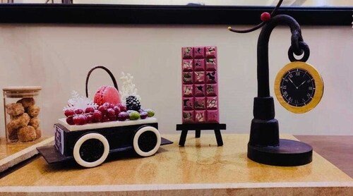 The hotel also created ruby chocolate cocoa nibs seed bar on chocolate easel stand; pistachio, almond, hazelnut, cranberry chocolate dragees and an edible chocolate hanging clock for the French President The hotel also created ruby chocolate cocoa nibs seed bar on chocolate easel stand; pistachio, almond, hazelnut, cranberry chocolate dragees and an edible chocolate hanging clock for the French President