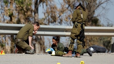 Israeli soldiers inspect a road for evidence and remains relating to the deadly October 7 attack by gunmen from Palestinian Islamist group Hamas, near Israel's border with Gaza in southern Israel (REUTERS)