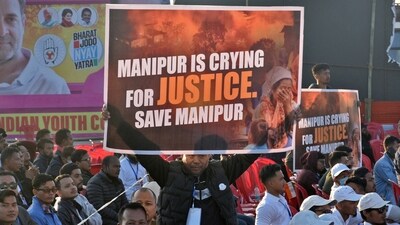A supporter of the Congress party holds up a banner during Rahul Gandhi's "Bharat Jodo Nyay Yatra" in Manipur's Thoubal district on January 14. (REUTERS)