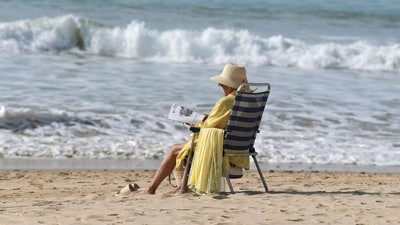 A woman reads in the sun on Victoria beach in Cadiz as temperatures around 30°C were recorded in Spain. (AFP) A woman reads in the sun on Victoria beach in Cadiz as temperatures around 30°C were recorded in Spain. (AFP)
