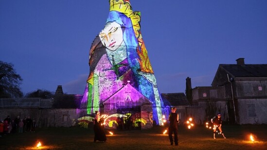 Dancers perform in front of an image of St. Brigid projected onto The Wonderful Barn in Leixlip, Kildare, Ireland, Tuesday, Jan. 31, 2023 during the Herstory Festival of Light. St Brigid's Day: Who was St. Brigid? Why is she inspiring many after 1,500 years of her death? (AP Photo/Peter Morrison, File)