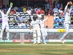 England's wicketkeeper Ben Foakes (L), Tom Hartley (R) and Joe Root (2R) celebrate after the dismissal of India's captain Rohit Sharma