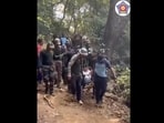 The image shows the members of Mumbai Police's Quick Response Team carrying the woman downhill in the makeshift stretcher. The image shows the members of Mumbai Police's Quick Response Team carrying the woman downhill in the makeshift stretcher.