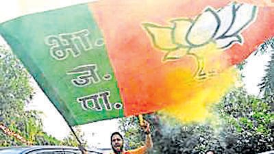 New Delhi, Dec 03 (ANI): A Bharatiya Janata Party (BJP) supporter waves the party flag during the celebrations as the party leads in the Madhya Pradesh, Rajasthan and Chhattisgarh Assembly elections, at the party headquarter, in New Delhi on Sunday. (ANI Photo/Shrikant Singh) (Shrikant Singh)