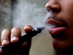 A man smokes a disposable vape, Newcastle-under-Lyme, Britain.