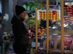 A customer holds a Russian rouble banknote while looking at foodstuffs at a market in Saint Petersburg, Russia.