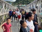 People who fled Myanmar carry their belongings across a bridge that connects Myanmar and India at the border village of Zokhawthar, Champhai district, in India’s northeastern state of Mizoram (REUTERS PHOTO)