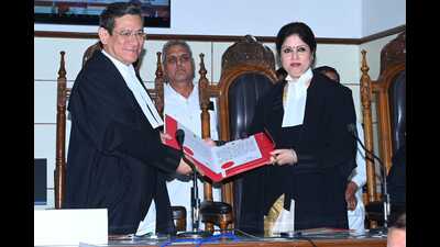 Chief justice N Kotiswar Singh presents a warrant of appointment to justice Moksha Khajuria Kazmi in Jammu on Monday. (HT Photo)