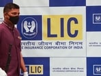 A man walks past a hoarding of Life Insurance Corporation of India (LIC) in Mumbai.