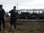 Agents of the Federal Police stand guard next to a burnt passenger bus after it crashed with a truck at the Mazatlan-Culiacan highway in the community of La Cruz, Sinaloa state, Mexico.