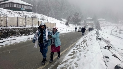 A tourist couple walks on a snow-covered road as the fresh snowfall breaks the two-month-long dry spell in Kashmir valley in Gulmarg. (ANI) A tourist couple walks on a snow-covered road as the fresh snowfall breaks the two-month-long dry spell in Kashmir valley in Gulmarg. (ANI)