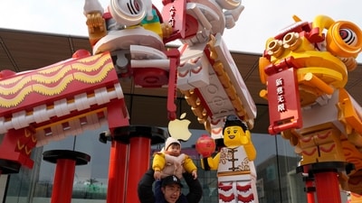 A man lifts a child on his shoulders near Chinese New Year themed decoration ahead of the upcoming Chinese Lunar New Year in Beijing, China on Saturday, Jan. 20, 2024. (AP Photo/Ng Han Guan) (AP)