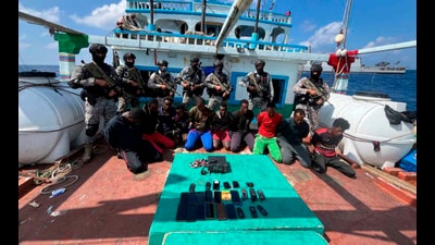 Commandos stand guard with a group of detained pirates after the Indian Navy freed a hijacked fishing vessel. (AP) Commandos stand guard with a group of detained pirates after the Indian Navy freed a hijacked fishing vessel. (AP)