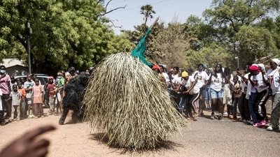 A performer wearing the traditional kumbo mask, a mythological figure of the jola tribe dressed with palm leaves, dances during the kankurang Festival in Janjanbureh on January 27, 2024. (Photo by MUHAMADOU BITTAYE / AFP) A performer wearing the traditional kumbo mask, a mythological figure of the jola tribe dressed with palm leaves, dances during the kankurang Festival in Janjanbureh on January 27, 2024. (Photo by MUHAMADOU BITTAYE / AFP)