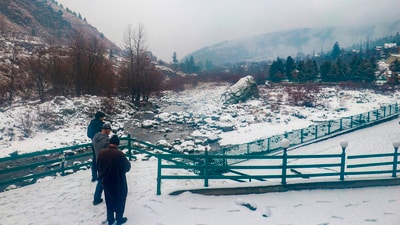 People stand at a snow covered field after light snowfall at Tangmarg in Baramulla district of north Kashmir. (PTI) People stand at a snow covered field after light snowfall at Tangmarg in Baramulla district of north Kashmir. (PTI)