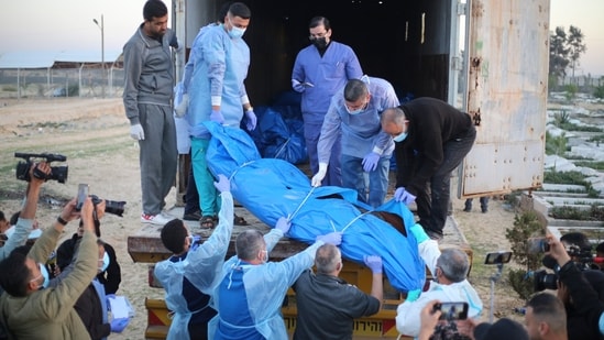Medics unload the bodies of Palestinians killed in the north of the Gaza Strip and turned over by the Israeli military during a mass funeral in Rafah. (AP)