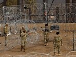 Members of the Texas National Guard place razor wire near the fence on the border with Mexico to inhibit the crossing of migrants into the U.S., as seen from Ciudad Juarez, Mexico January 23, 2024. REUTERS/Jose Luis Gonzalez