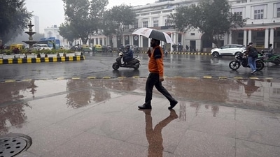 Commuters during a sudden spell of rain at Connaught Place in New Delhi on Wednesday. (Sanjeev Verma/ HT Photo)