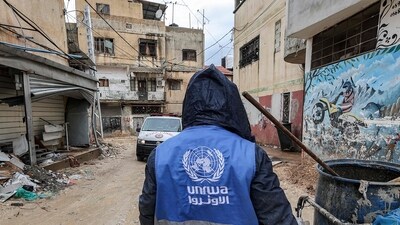 A man collects trash while wearing a jacket bearing the logo of the United Nations Relief and Works Agency for Palestine Refugees in the Near East (UNRWA) (AFP/Representational image)