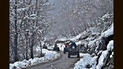 Tourists enjoy an ATV ride along a snow-covered road in Tangmarg, in Baramulla district on Wednesday. (Waseem Andrabi?HT)