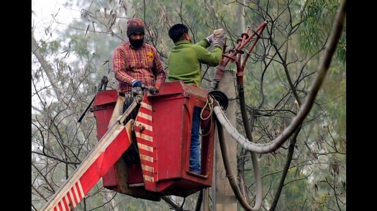 Repair work being carried out by two lineman in Ludhiana on Wednesday. (HT Photo)