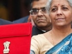 Finance minister Nirmala Sitharaman holds up a folder as she leaves her office to present the interim budget. (REUTERS)