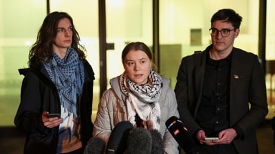 Climate activist Greta Thunberg gives a statement next to activist Chris Kebbon and Joshua James Unwin outside Westminster Magistrates' Court (REUTERS)