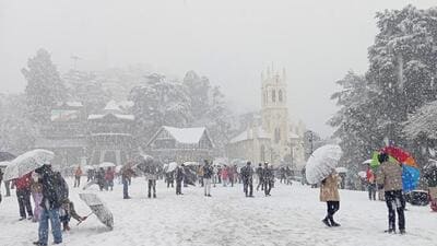Tourists and residents enjoying the snowfall at the Ridge in Shimla on Thursday. (Deepak Sansta/HT)