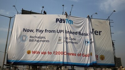 Workers adjust a hoarding of Paytm, a digital payments firm, in Ahmedabad. (REUTERS)