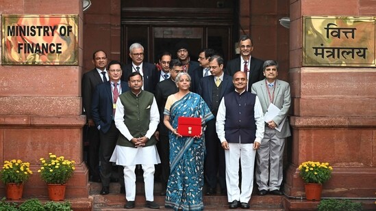 Finance Minister Nirmala Sitharaman (C) along with her staff poses for pictures as she leaves the Finance Ministry Office to present the annual budget in parliament in New Delhi on February 1, 2024. Finance Minister Nirmala Sitharaman (C) along with her staff poses for pictures as she leaves the Finance Ministry Office to present the annual budget in parliament in New Delhi on February 1, 2024.