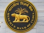 A security official walks past an emblem of the Reserve Bank of India at the RBI headquarters, in Mumbai.