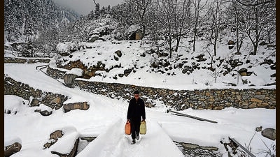 A man walks on a snow-covered road in Srinagar on Friday. (Waseem Andrabi/HT) A man walks on a snow-covered road in Srinagar on Friday. (Waseem Andrabi/HT)