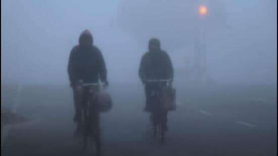 People commute amid dense fog in Dwarka, southwest Delhi on Friday. (Vipin Kumar/ HT Photo)