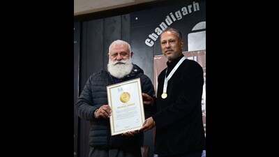Former Test cricketer Yograj Singh handing over a citation to Jeev Milkha Singh in Chandigarh on Saturday. (Ravi Kumar/HT) Former Test cricketer Yograj Singh handing over a citation to Jeev Milkha Singh in Chandigarh on Saturday. (Ravi Kumar/HT)