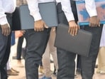 Candidates stand in a row at a job fair. Candidates stand in a row at a job fair.