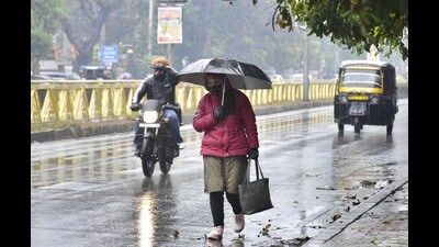 Commuters making their way through rain in Amritsar on Sunday. (Sameer Sehgal /HT)