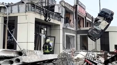 Russian Emergency Ministry employees work at the side of a collapsed bakery after an attack of Ukrainian troops. (AP)