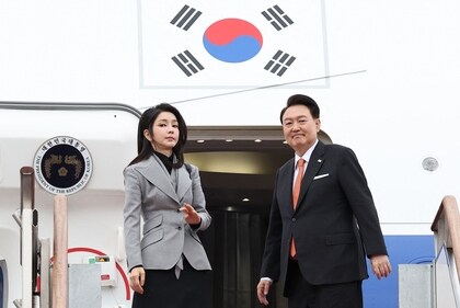 South Korea's President Yoon Suk Yeol (R) and his wife Kim Keon Hee (L) board their aircraft at Seoul Air Base in Seongnam on December 11, 2023, (AFP)