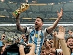FILE - Argentina's Lionel Messi celebrates with the trophy in front of the fans after winning the World Cup final match between Argentina and France FILE - Argentina's Lionel Messi celebrates with the trophy in front of the fans after winning the World Cup final match between Argentina and France
